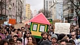 Protestors carry a mock house, during a demonstration to demand solutions for Portugal's housing crisis, in Lisbon, Saturday, April 1, 2023. 