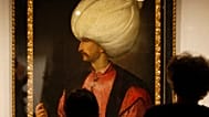 ينظر الزوار إلى لوحة السلطان سليمان الأول العظيم، المنسوبة إلى مدرسة الرسام الإيطالي تيتيان، 1530