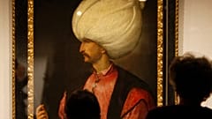 ينظر الزوار إلى لوحة السلطان سليمان الأول العظيم، المنسوبة إلى مدرسة الرسام الإيطالي تيتيان، 1530