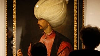 ينظر الزوار إلى لوحة السلطان سليمان الأول العظيم، المنسوبة إلى مدرسة الرسام الإيطالي تيتيان، 1530
