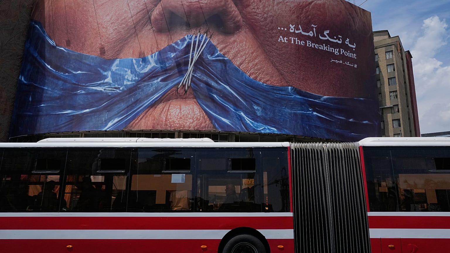 لوحة إعلانية تُظهر مضيق هرمز وشفاه الرئيس الأميركي دونالد ترامب مخيطة، في ساحة وسط العاصمة الإيرانية طهران، السبت 2 مايو/أيار 2026.