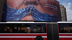 لوحة إعلانية تُظهر مضيق هرمز وشفاه الرئيس الأميركي دونالد ترامب مخيطة، في ساحة وسط العاصمة الإيرانية طهران، السبت 2 مايو/أيار 2026.