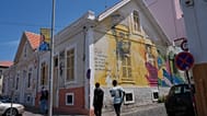 Arquivo (7.05.2026): As pessoas passam por um grafite de Amílcar Cabral num edifício na Praia, em Cabo Verde,