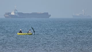 Μια μικρή βάρκα με φόντο δεξαμενόπλοια στα στενά του Ορμούζ