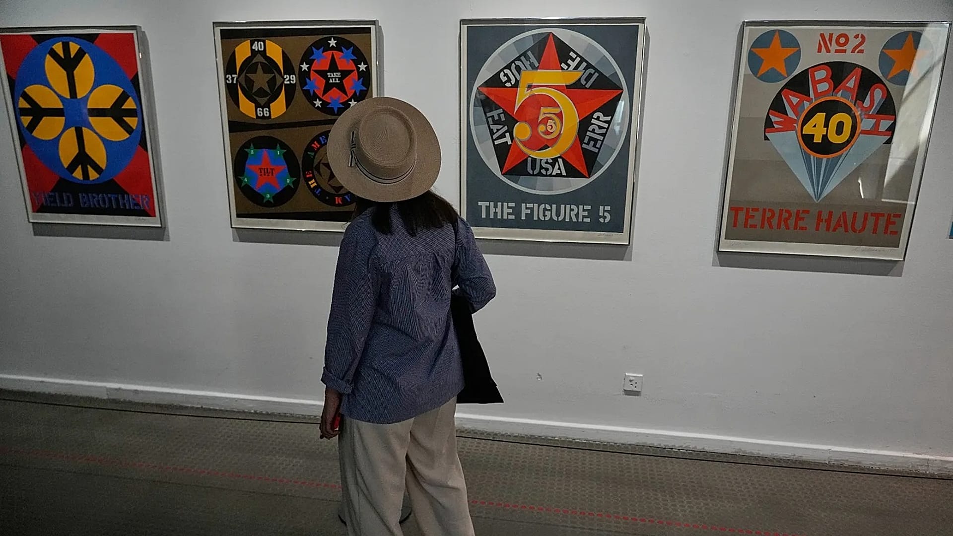 Die iranische Künstlerin Ghazaleh Jahanbin betrachtet Siebdrucke des US-Künstlers Robert Indiana in der Schau „Art & war“ mit Werken US-amerikanischer Künstler.