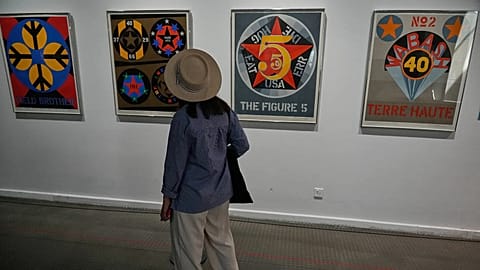 Iranian Artist Ghazaleh Jahanbin looks at screenprints of American artist Robert Indiana as she visits an exhibition called: "Art & war" displaying some artworks of American