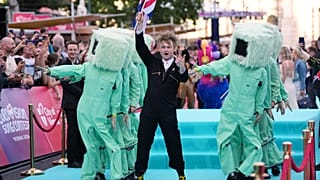 A brit Look Mum No Computer művész a türkizkék szőnyegen sétál az Eurovíziós Dalfesztivál hetének hivatalos kezdetén a bécsi városházán, 2026. május