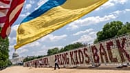 Demonstrators wave American and Ukrainian flags as thousands of teddy bears representing children deported from Ukraine by Russia since the start of its invasion in 2022.