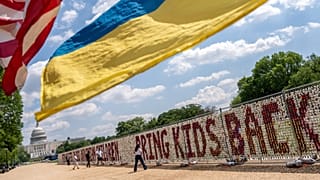 Demonstrators wave American and Ukrainian flags as thousands of teddy bears representing children deported from Ukraine by Russia since the start of its invasion in 2022.