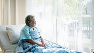 Eine Frau sitzt im Krankenhausbett und blickt ins Licht. Nach einer Hantavirus-Infektion leiden viele weiter unter körperlichen und seelischen Folgen.