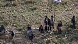 Alumnos palestinos caminan a la escuela a lo largo de la valla que separa su pueblo del cercano asentamiento israelí de Carmel, lo que les obliga a tomar una ruta alternativa casi dos veces al día.