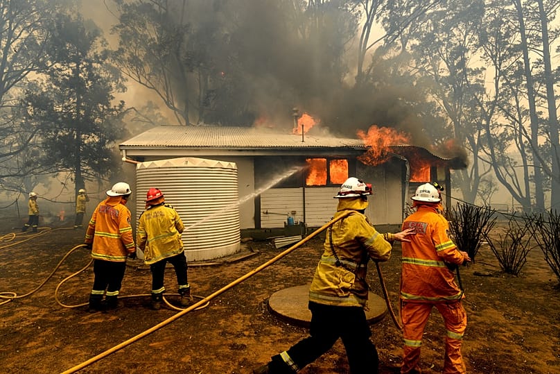 Feuerwehrleute bekämpfen den Morton-Brand, der am Donnerstag, 23. Januar 2020, ein Haus nahe Bundanoon im australischen Bundesstaat New South Wales in Australien bedroht.