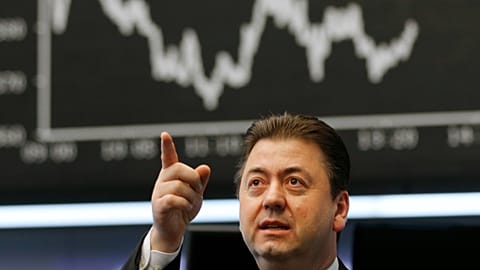 A trader gestures at the stock market in Frankfurt, Germany