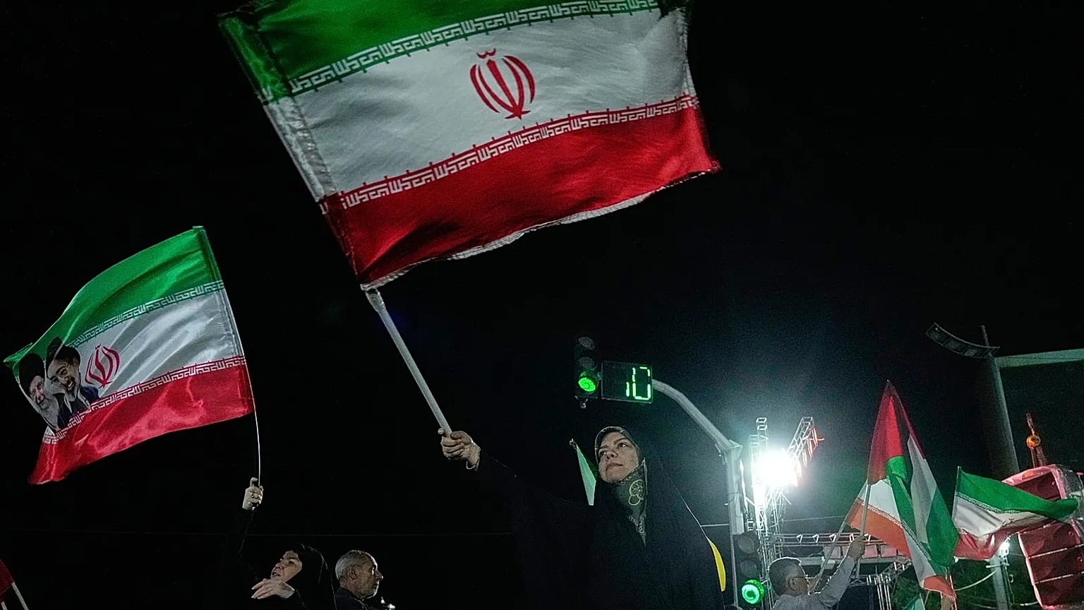 Pro-government demonstrators wave Iranian flags during a gathering in Tehran, 27 April, 2026