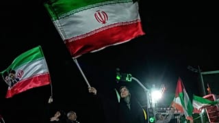 Pro-government demonstrators wave Iranian flags during a gathering in Tehran, 27 April, 2026