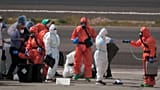 ركاب يُرشّون بمواد مطهّرة بعد نزولهم من السفينة “إم في هونديوس” في مطار تينيريفي بجزر الكناري في إسبانيا، الأحد 10 مايو/أيار 2026