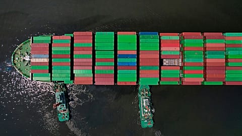 FILE - Tugboats assist a container ship as it prepares to dock at the Manila International Container Terminal at the Philippine capital, 8 April 2025.
