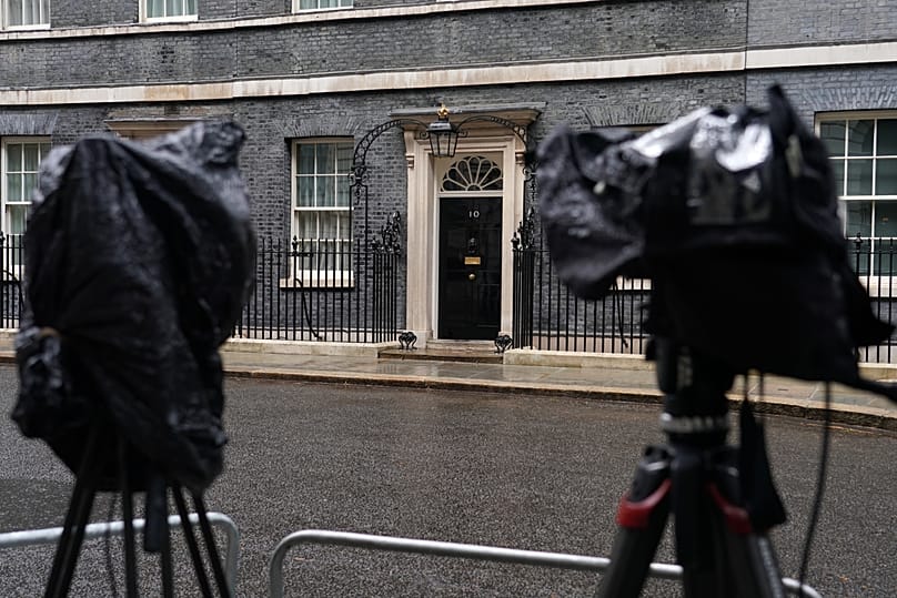 Cameras are covered with rain covers as journalists wait for a showing of Britain's Prime Minister Keir Starmer at 10 Downing Street in London, 11 May, 2026
