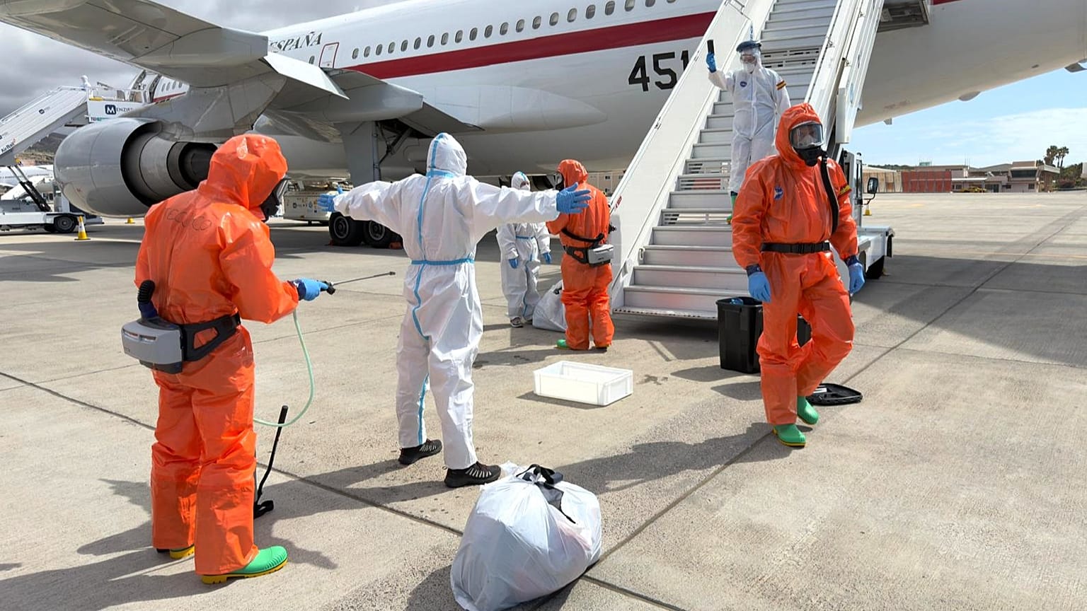 A Spanish passenger is sprayed with disinfectant by Spanish government officials before boarding a plane after disembarking from the MV Hondius, Spain, Sunday, May 10, 2026. 