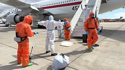 Un passeggero spagnolo viene disinfettato da funzionari governativi prima di salire su un aereo, dopo lo sbarco dalla MV Hondius, in Spagna, domenica 10 maggio 2026.