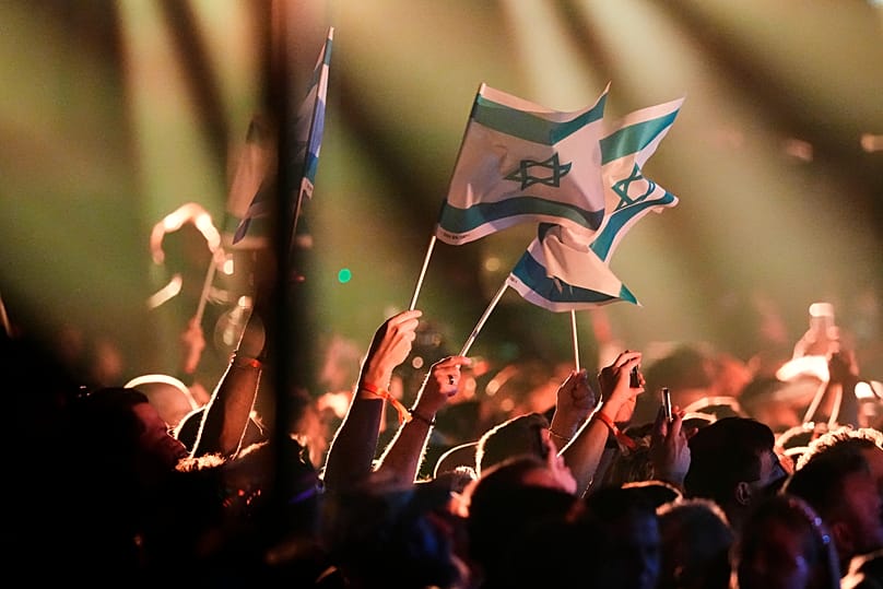 Israeli flags waved by members of the crowd as Noam Bettan from Israel performs during the first semifinal of the 70th Eurovision Song Contest in Vienna, May 12, 2026. 
