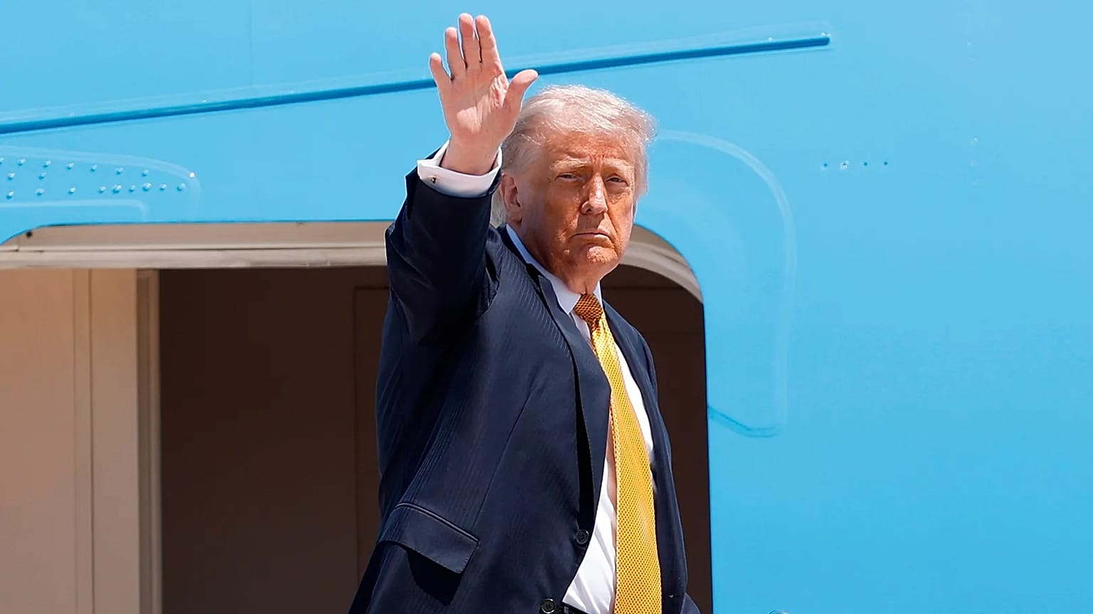 US President Donald Trump waves from the stairs of Air Force One as he boards at Joint Base Andrews, 12 May, 2026