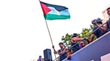 Il giocatore del Barcellona Lamine Yamal mostra una bandiera palestinese mentre festeggia con la squadra su un bus dopo il titolo della Liga a Barcellona.