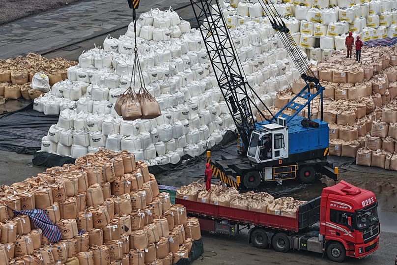Workers transfer bags of imported solid sulfur onto a truck in a port in Nanjing in eastern China's Jiangsu province, April 14, 2026. (Chinatopix Via AP) 