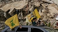 نازحون يلوّحون بأعلام "حزب الله" وصورة أمينه العام نعيم قاسم وسط الدمار في الضاحية الجنوبية لبيروت، الجمعة 17 أبريل 2026.