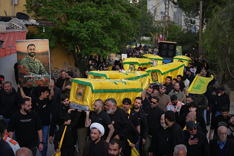 مشيّعون يحملون نعوش مقاتلين من "حزب الله" في بلدة كفرصير جنوب لبنان، في 21 أبريل/نيسان 2026.