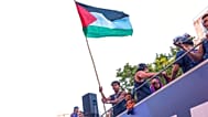 FC Barcelona player Lamine Yamal holds a Palestinian flag as he celebrates with his team atop a bus after winning the Spanish La Liga title in Barcelona, Spain, Monday, May 11