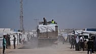 FILE: Trucks carrying food, after entering the Gaza Strip through the Kerem Shalom crossing, drive through Khan Younis, 1 February 2026