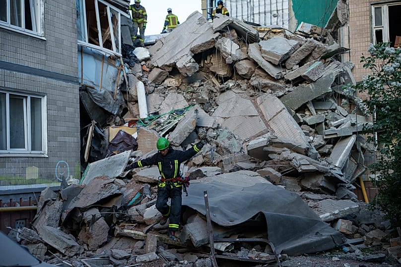 A rescue worker walks on the rubble of a house heavily damaged after a Russian strike on residential neighbourhood in Kyiv, Ukraine, on Thursday, May 14, 2026.
