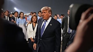 يمشي الرئيس دونالد ترامب خلال حفل الترحيب لدى وصوله على متن طائرة الرئاسة، الأربعاء 13 مايو 2026، إلى مطار العاصمة بكين الدولي في بكين. (صورة AP/مارك شيفيلباين)