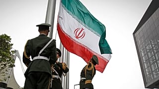 رجال الشرطة شبه العسكرية الصينية يرفعون العلم الإيراني خلال مراسم رفع العلم أثناء زيارة الرئيس الإيراني محمود أحمدي نجاد لمعرض شنغهاي العالمي في شنغهاي، الصين، يوم الجمعة 11 ي