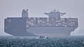 FILE: A container ship sits at anchor as a small motorboat passes in the foreground in the Strait of Hormuz off Bandar Abbas, 2 May 2026