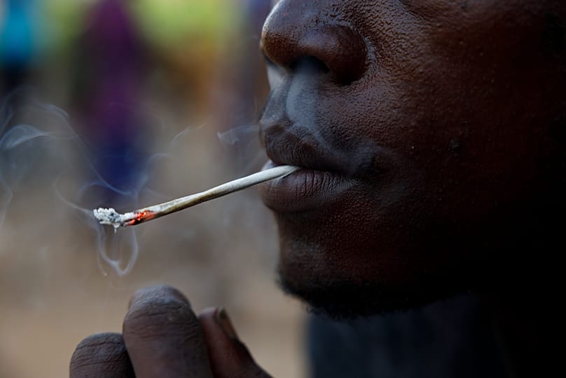 Un jeune homme fume du "Kush" dans un repaire de Freetown, en Sierra Leone, le 29 avril 2024
