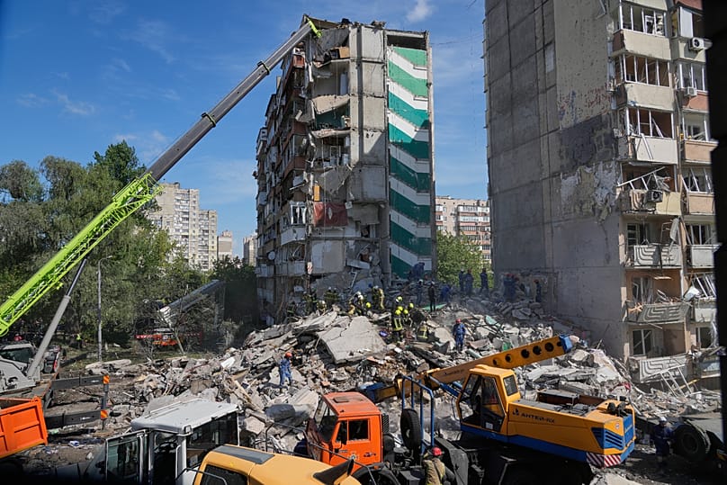 Rescuers clear the rubble after a Russian missile hit an apartment building during massive air attack in Kyiv, 14 May, 2026