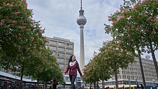 Eine Frau geht vor dem Fernsehturm am Alexanderplatz in Berlin, 11. Mai 2026.
