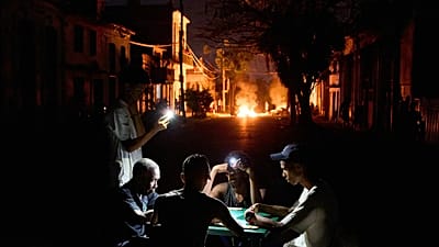 Menschen beleuchten sich selbst mit ihren Handys, während in Havanna ein Feuer brennt, das von Anwohnern aus Protest gegen die anhaltenden Stromausfälle gelegt wurde, 14. Mai 2026