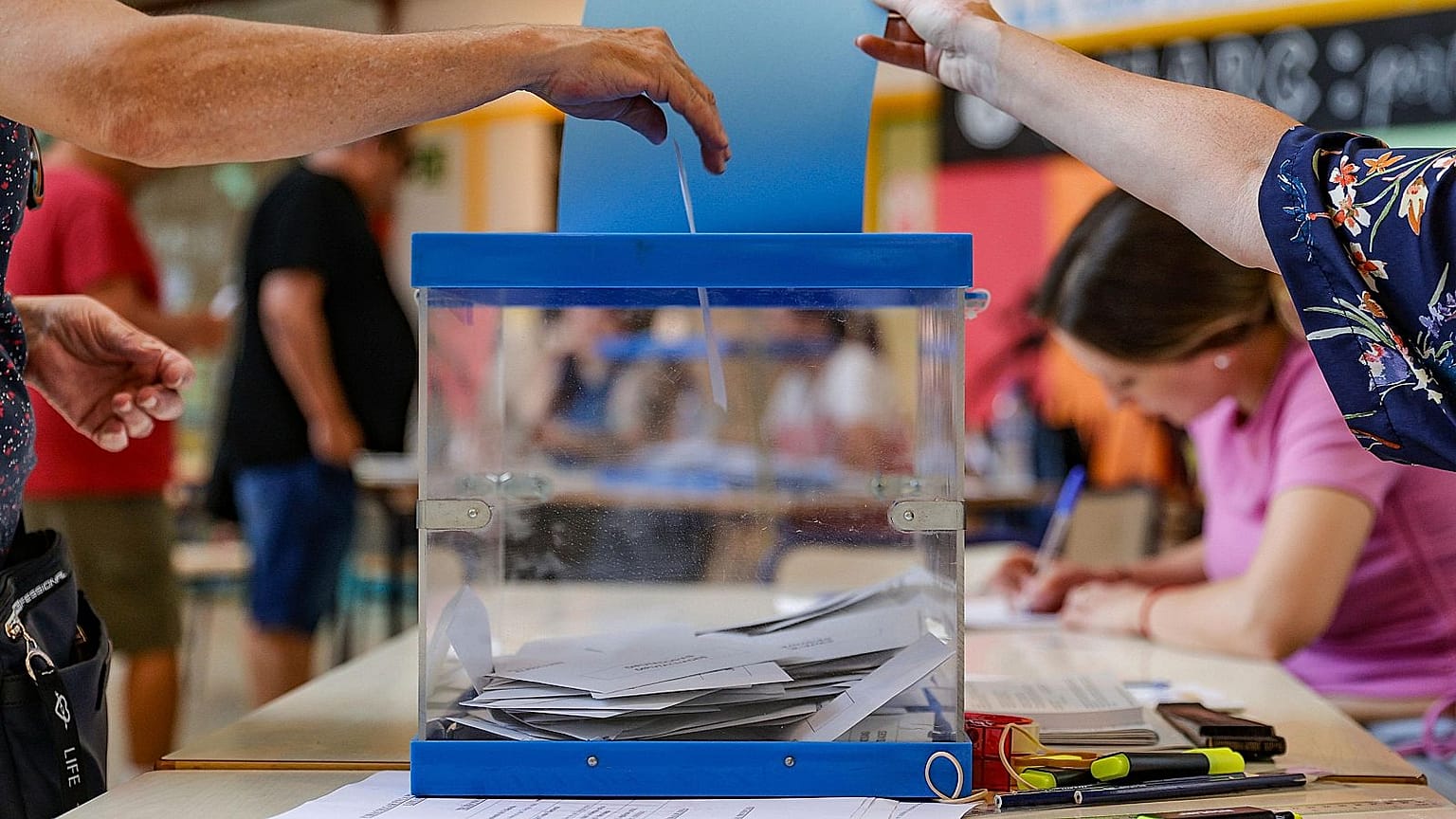 Una mujer deposita su voto en un colegio electoral