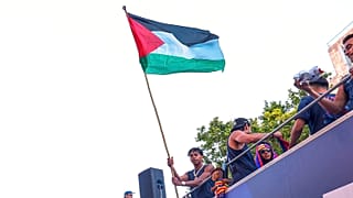 FC Barcelona player Lamine Yamal holds a Palestinian flag as he celebrates with his team atop a bus after winning the Spanish La Liga title in Barcelona, 11 May, 2026
