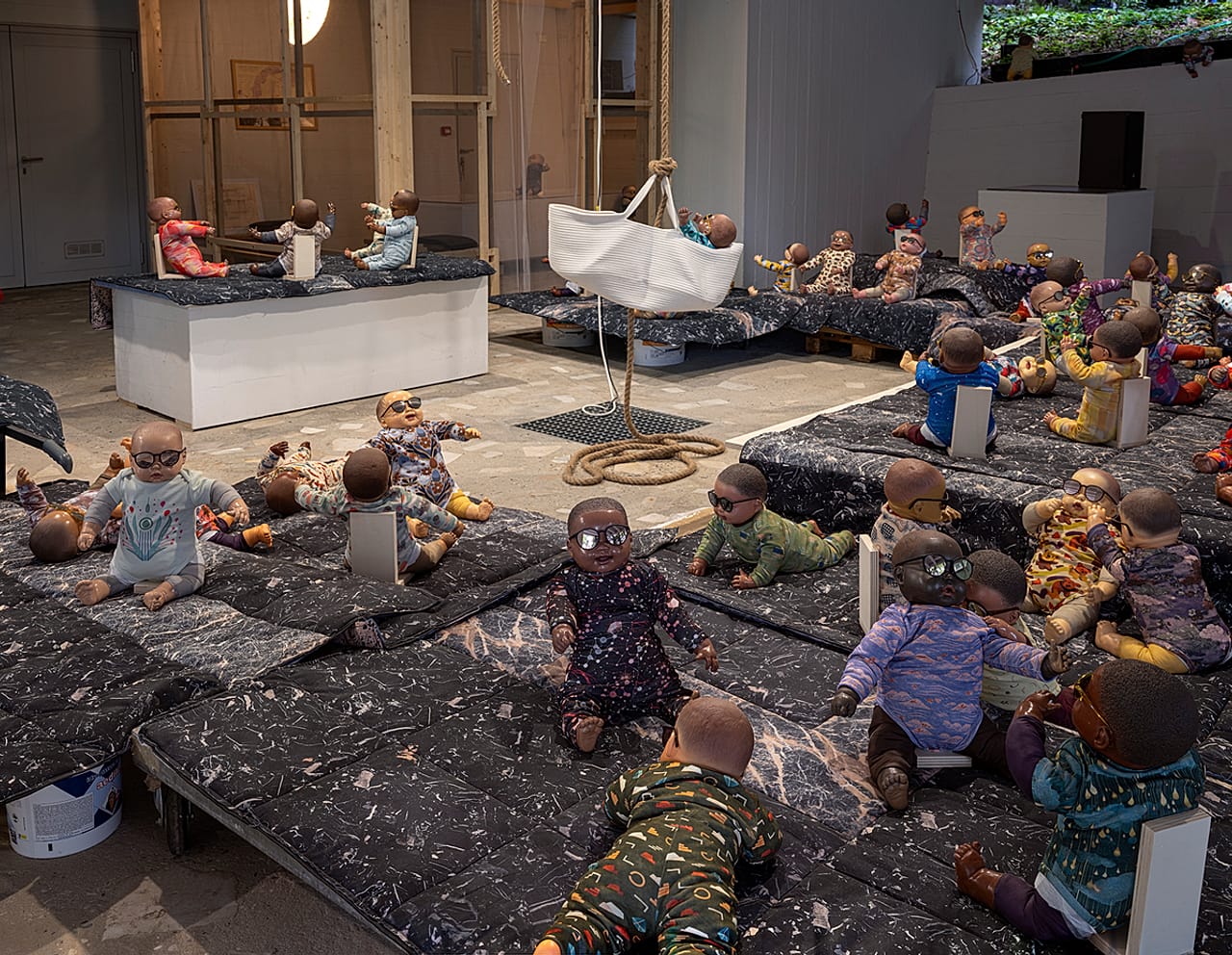Upon entering, visitors are invited to carry one of 57 dolls – in funky onesies and sunglasses – through the Pavilion’s pilotis, gardens and interior spaces.