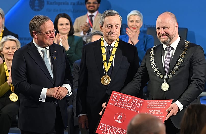 L'ancien président de la BCE, Mario Draghi, au centre, sourit après avoir reçu le prix Charlemagne à Aix-la-Chapelle, en Allemagne, le jeudi 14 mai 2026