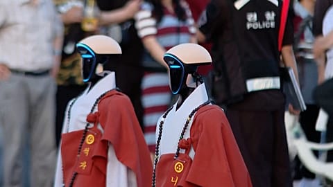 Humanoid robots dressed as monks at the parade celebrating Buddha's birthday