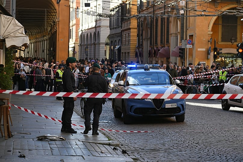 Police patrol a scene after a car incident in a street of Modena, Italy, Saturday, May 16, 2026. 