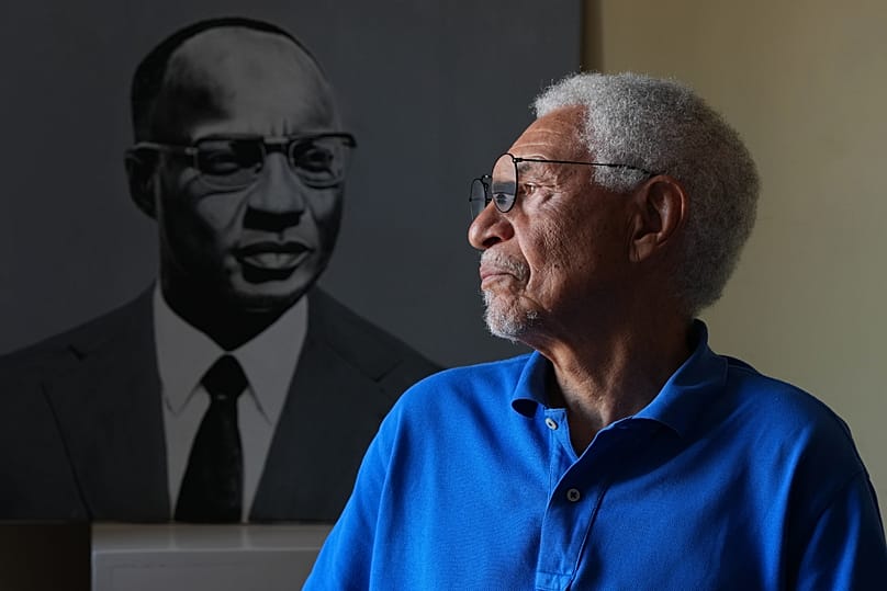 Adao Rocha, direttore del Museo Amílcar Cabral, è seduto accanto a un ritratto di Amílcar Cabral, a Praia, 