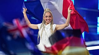 Monroe fait son entrée sur scène en brandissant le drapeau français avant la grande finale du 70e Concours Eurovision à Vienne, en Autriche, le samedi 16 mai 2026. 