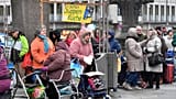 Deserving poor wait in lines behind a sign reading 'Soup Kitchen' to get free food at the old town of Cologne, Germany, Friday, Nov. 11, 2016. 