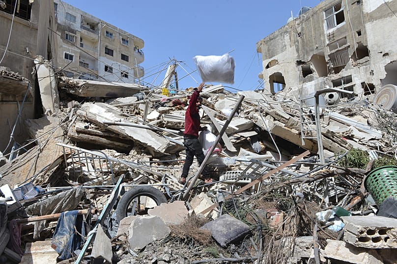 A man collects family's belongings from the rubble of a building destroyed in an Israeli airstrike in the southern village of Maarakeh, Lebanon, Sunday, May 17, 2026